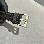 Black textured watch strap with metal buckle clasp, black fabric and silver hardware