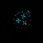 Round watch dial with glowing blue luminous numerals and hands on dark face