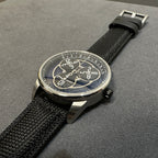Audemars Piguet round watch with black textured strap and blue-accented skeleton dial