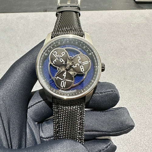Audemars Piguet round watch with black textured fabric strap and blue dial accents