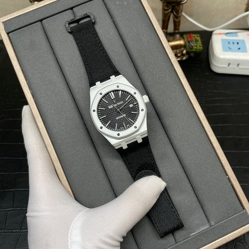 Audemars Piguet wristwatch shown on dark cushion, black dial and black fabric strap