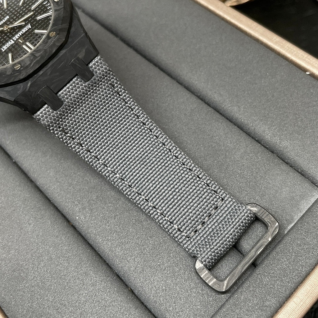 Audemars Piguet watch strap close-up, black textured mesh with metal buckle