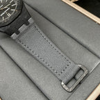 Audemars Piguet watch strap close-up, black textured mesh with metal buckle