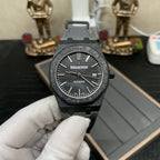 Audemars Piguet watch on dark surface, black dial with date window and black strap