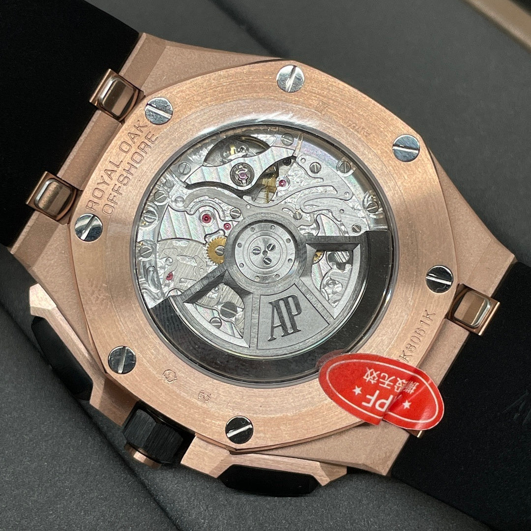 Rose gold watch caseback with visible mechanical movement and black rubber strap