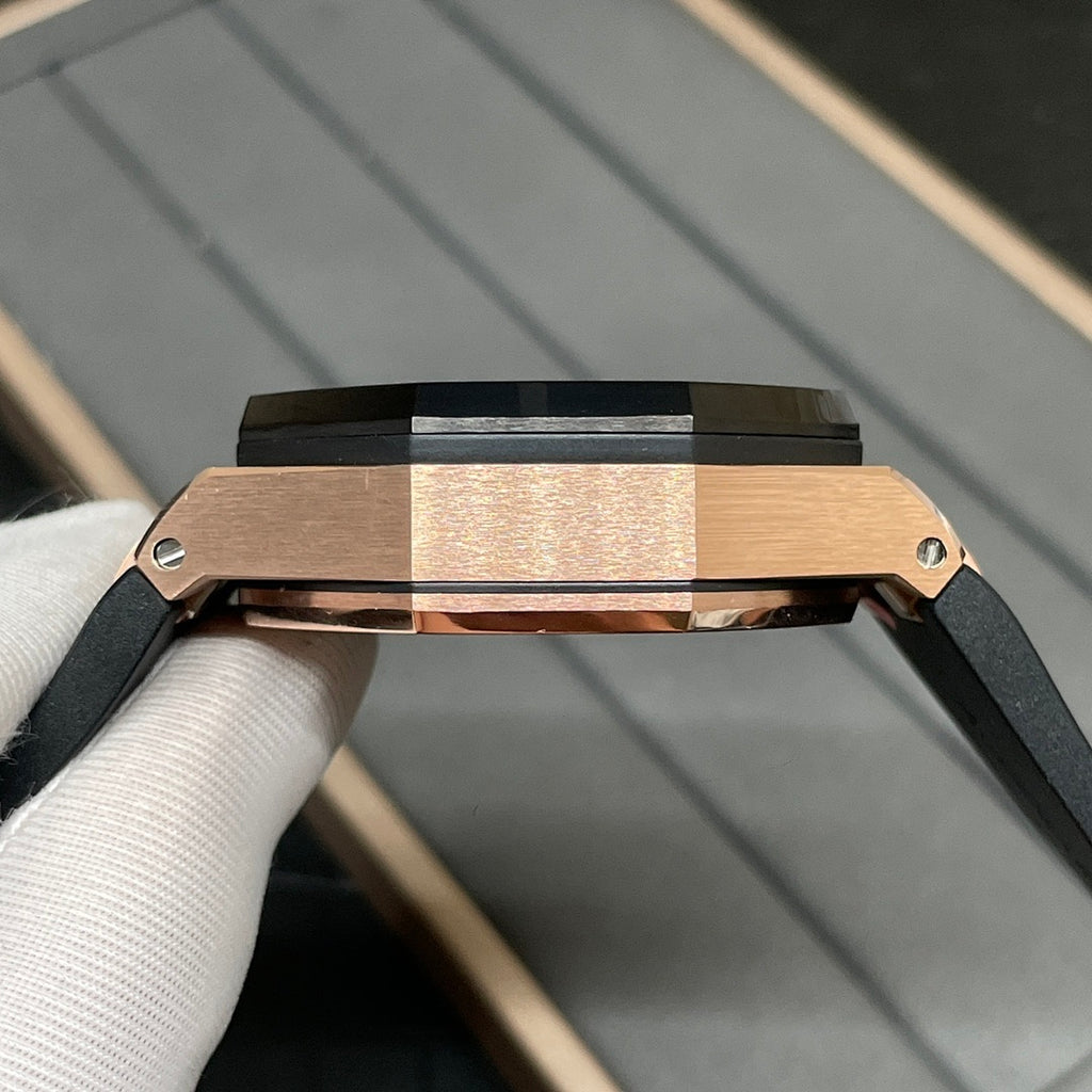 Rose gold watch case with black strap and crown, shown in side profile