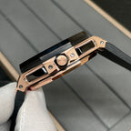 Rose gold watch case with black crown area and black rubber strap, side profile