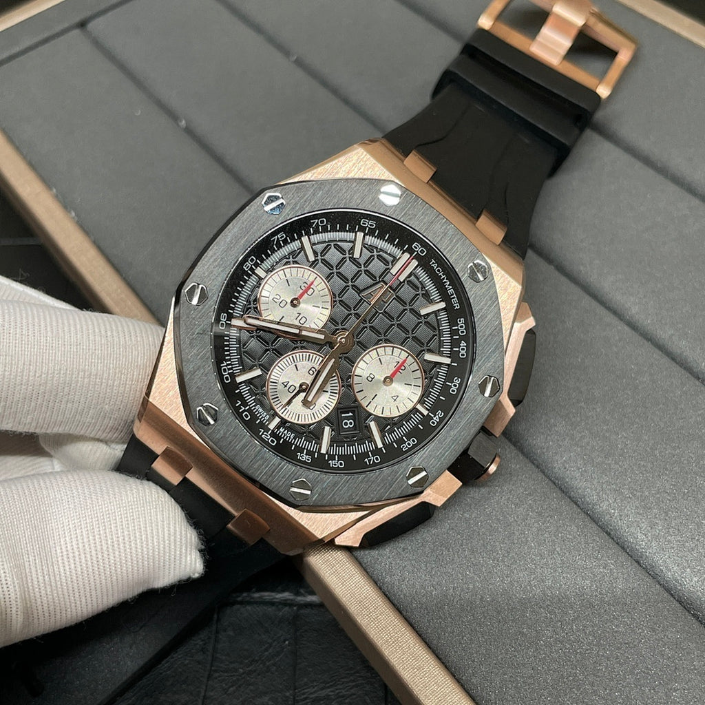 Rose gold chronograph watch with black dial and three subdials on black rubber strap