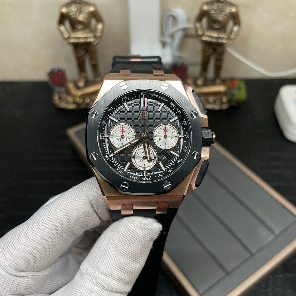 Rose gold chronograph watch with black dial and three subdials, on black rubber strap