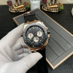 Rose gold chronograph watch with black dial and three subdials, resting on box padding
