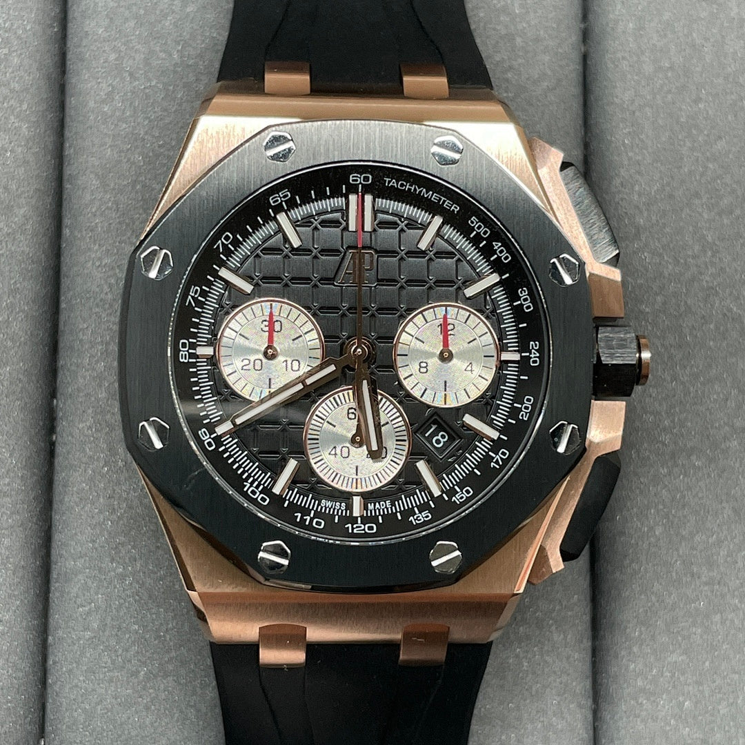 Rose gold chronograph watch with black dial, three subdials, and black rubber strap