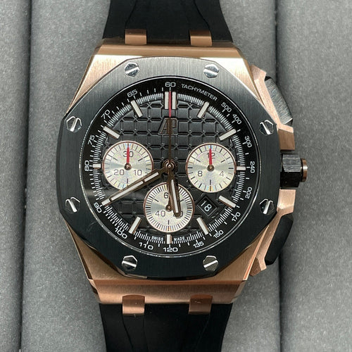 Rose gold chronograph watch with black dial, three subdials, and black rubber strap
