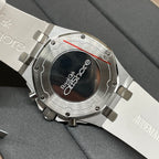 Luxury wristwatch case back with engraved text and metallic bracelet, close-up