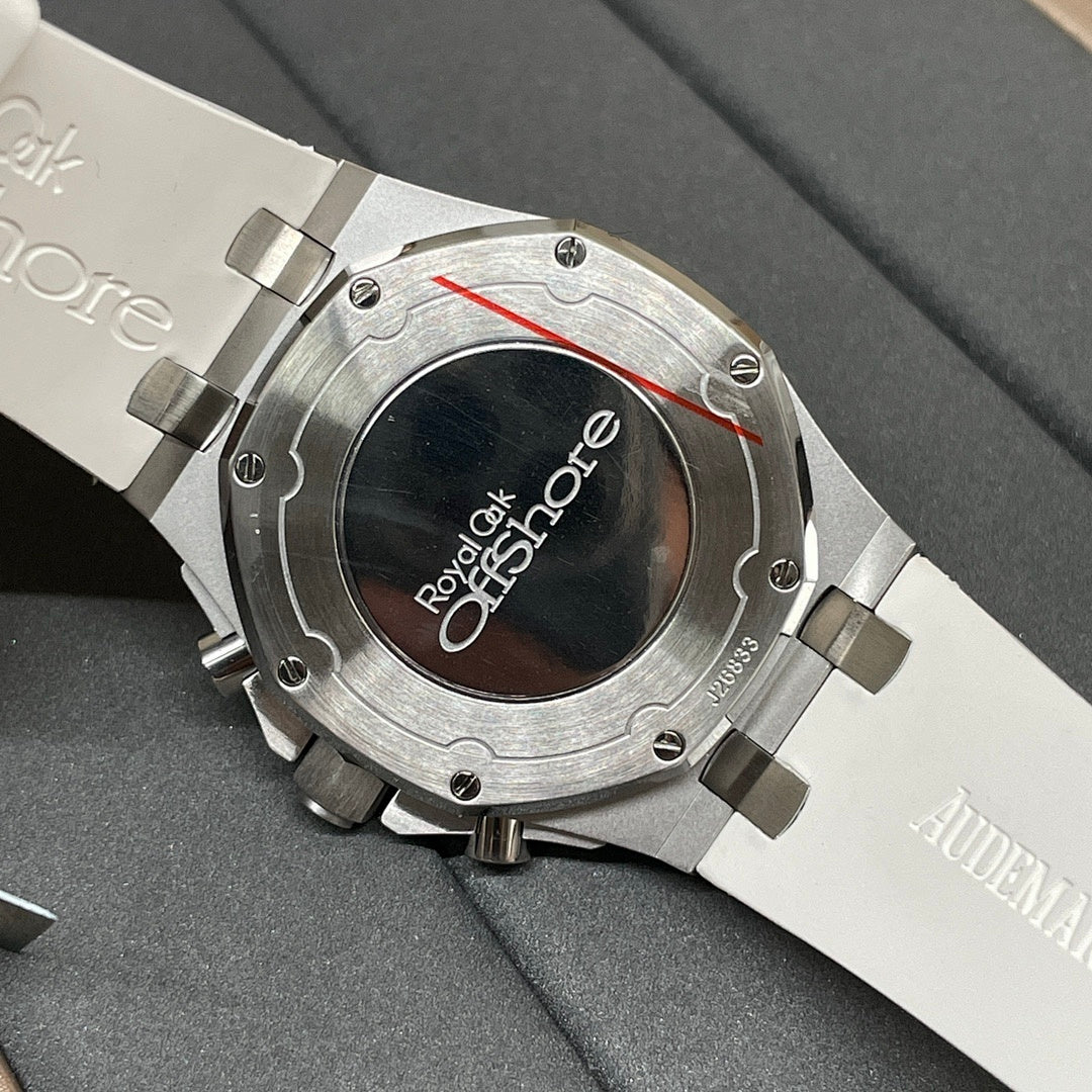 Luxury wristwatch case back with engraved text and metallic bracelet, close-up