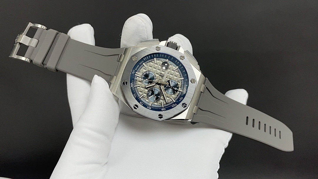 Stainless steel wristwatch on white strap, blue dial viewed at an angle