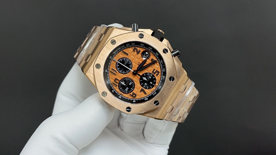 Audemars Piguet chronograph watch, gold-tone case, orange dial, angled view