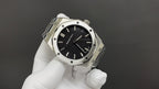 Audemars Piguet watch angled view with black dial, steel bezel, and integrated bracelet