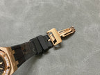 Rose gold-tone buckle clasp on black rubber watch strap