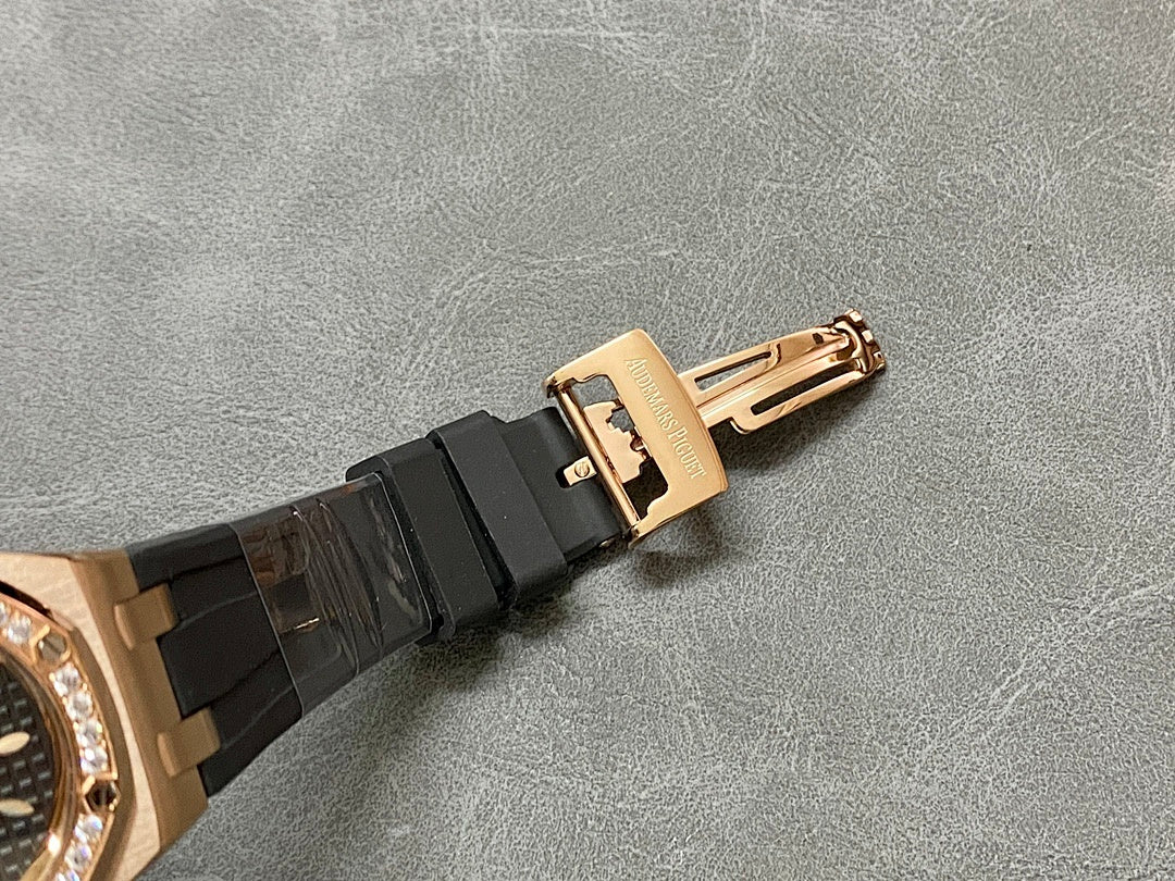 Rose gold-tone buckle clasp on black rubber watch strap