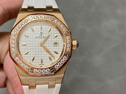 Rose gold-tone wristwatch with white dial, diamond bezel, and white rubber strap.