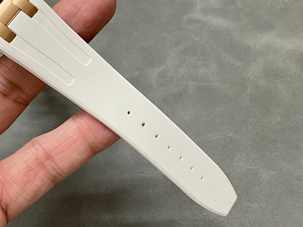 White rubber watch strap with perforations and stitched clasp end.