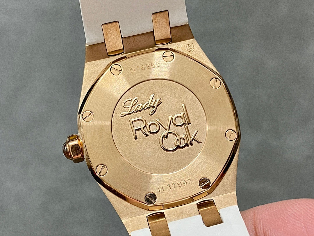 Rose gold-tone case back with “Lady Royal Oak” text and white rubber strap.