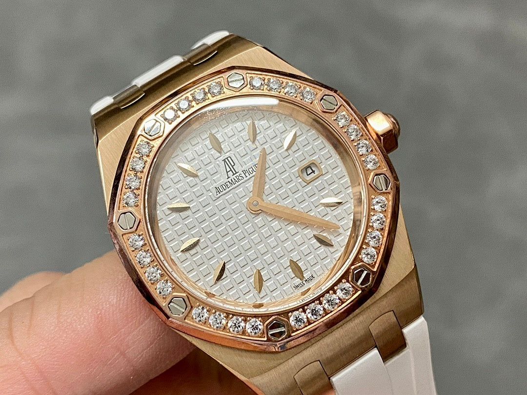 Rose gold-tone wristwatch with white dial, diamond bezel, and white rubber strap.
