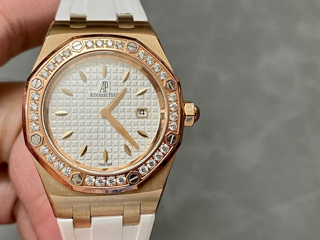 Rose gold-tone watch with white textured dial, diamond bezel, and white rubber strap.