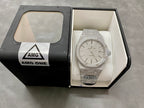 Silver-toned diamond-studded watch displayed in open box on white cushion