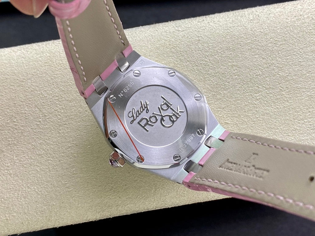 Steel watch caseback with engraved design and pink strap underside