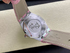 Steel watch caseback with engraved design and pink strap underside