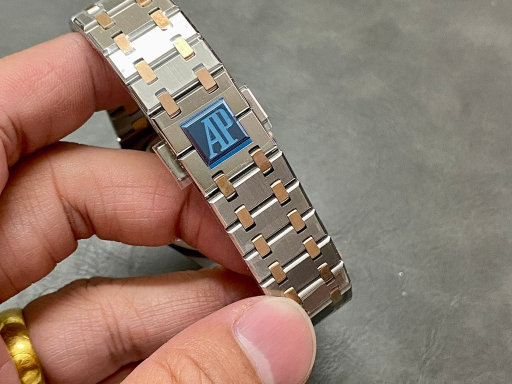 Audemars Piguet watch bracelet clasp and case side, steel links with gold accents