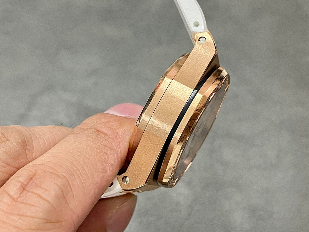 Rose-gold watch case with white rubber strap, side view of the bezel and lugs
