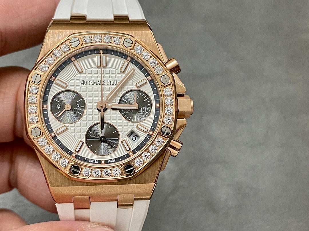 Audemars Piguet chronograph watch face with diamond bezel, rose-gold case, white rubber strap