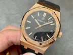 Rose-gold luxury wristwatch with black textured dial and black rubber strap.