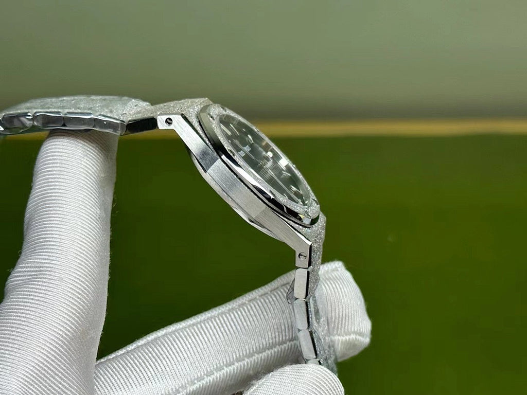 Silver-tone steel watch with curved case and bracelet links, held by white gloves