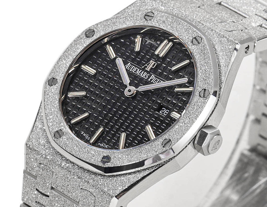 Audemars Piguet stainless steel watch face with dark dial, baton hands, and date at 28
