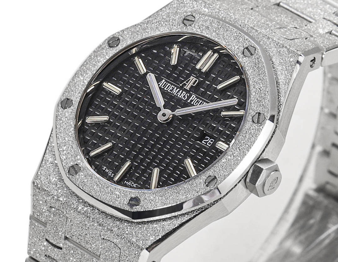 Audemars Piguet stainless steel watch face with dark dial, baton hands, and date at 28