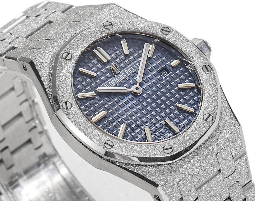 Silver watch with blue patterned dial, baton hour markers, and hands