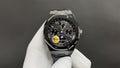 Audemars Piguet watch with black dial, chronograph subdials, and steel bracelet