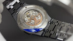 Audemars Piguet watch with exposed movement and steel bracelet, caseback view