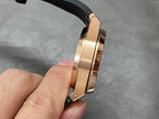 Rose gold watch case side with black rubber strap, screws and pushers