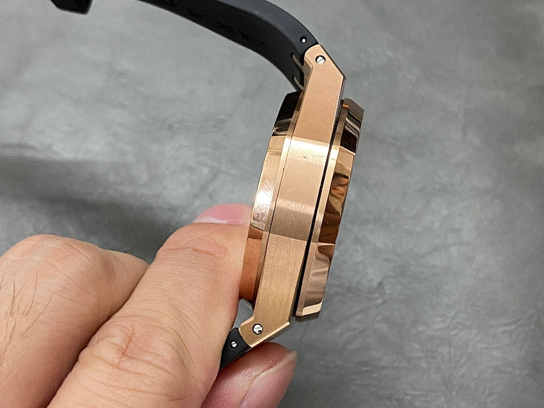 Rose gold watch case side with black rubber strap, screws and pushers