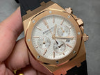 Rose gold chronograph watch with silver dial, black rubber strap, subdials and date window