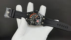 Audemars Piguet watch on black rubber strap with orange dial and visible hands