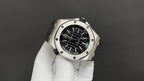 Stainless steel watch with black dial and bezel screws, angled view