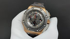 Octagonal watch with dark dial, gold-tone bezel, and gray strap