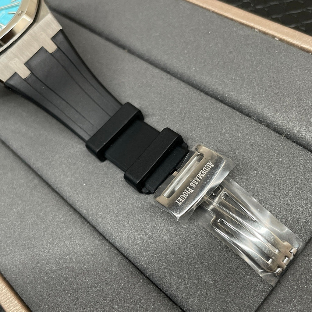 Audemars Piguet watch with black rubber strap and metal clasp on gray box