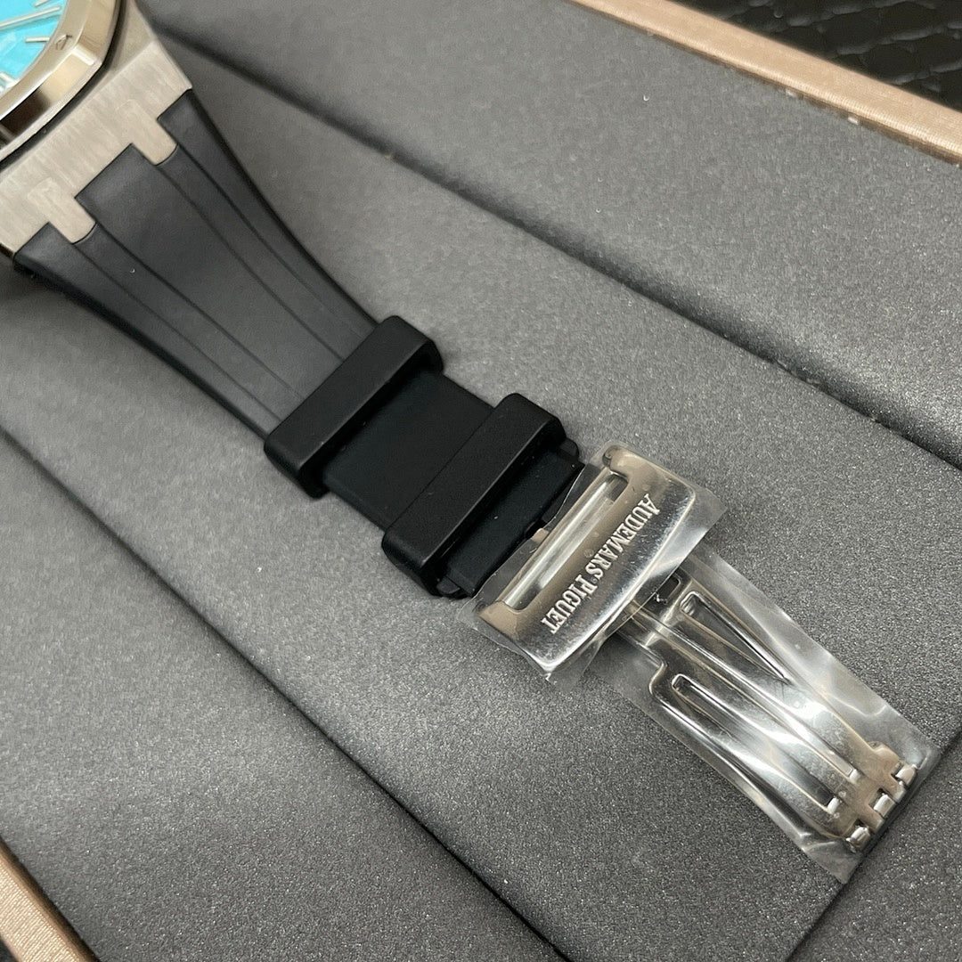 Audemars Piguet watch with black rubber strap and metal clasp on gray box