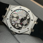 Audemars Piguet watch with exposed skeleton dial, metallic case, and black rubber strap